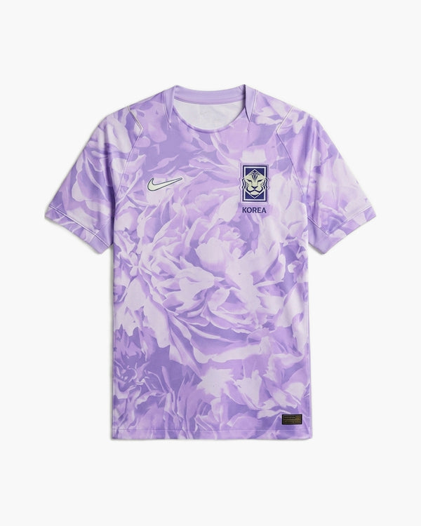 South Korea 2026 away football shirt by Nike, lilac purple with an all-over peony print, pale lime Swoosh and the navy KFA tiger crest above KOREA, front view — CRID