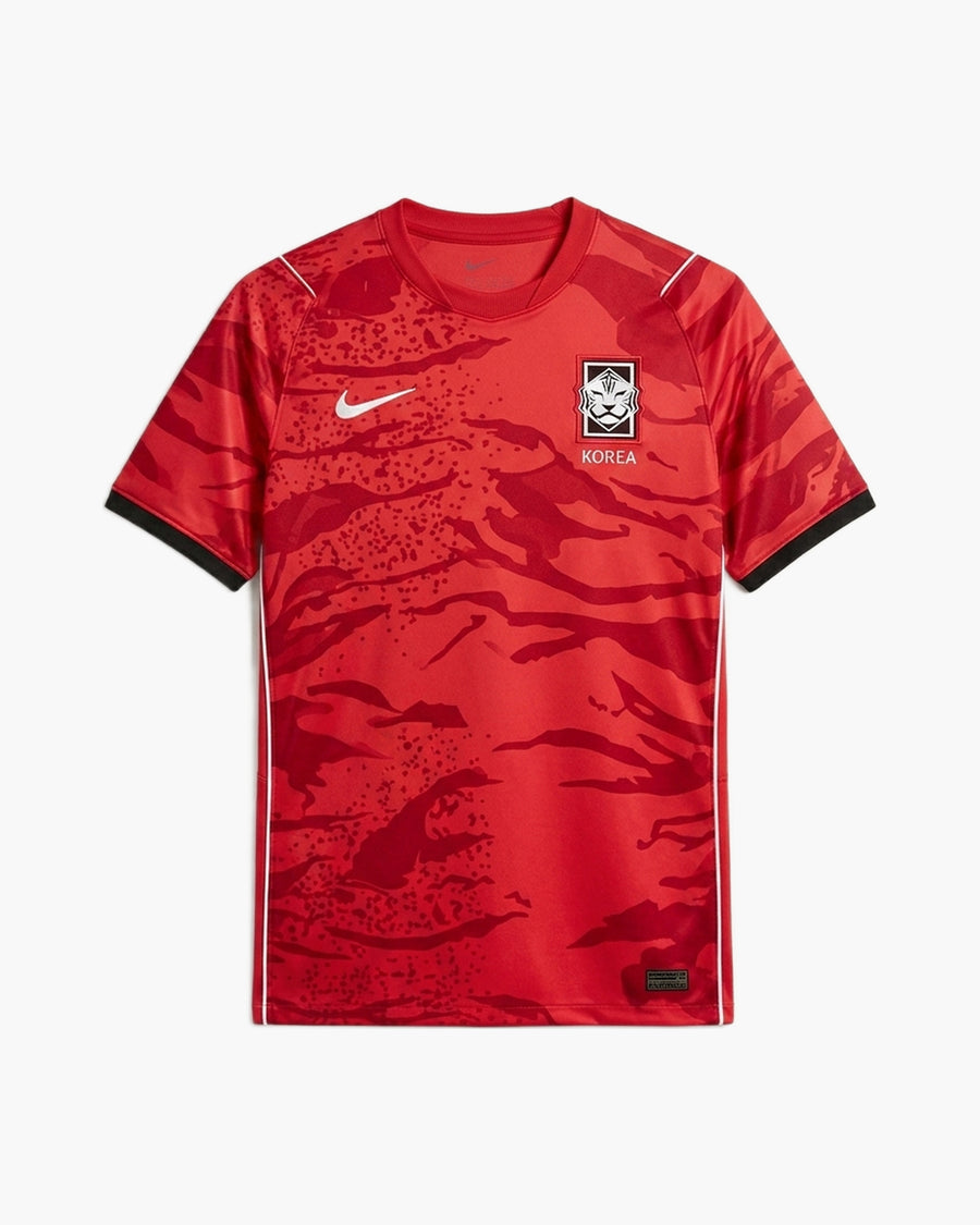 South Korea 2026 home football shirt by Nike, red with a tonal tiger-stripe camouflage, the white Swoosh and the KFA tiger crest above KOREA, front view — CRID